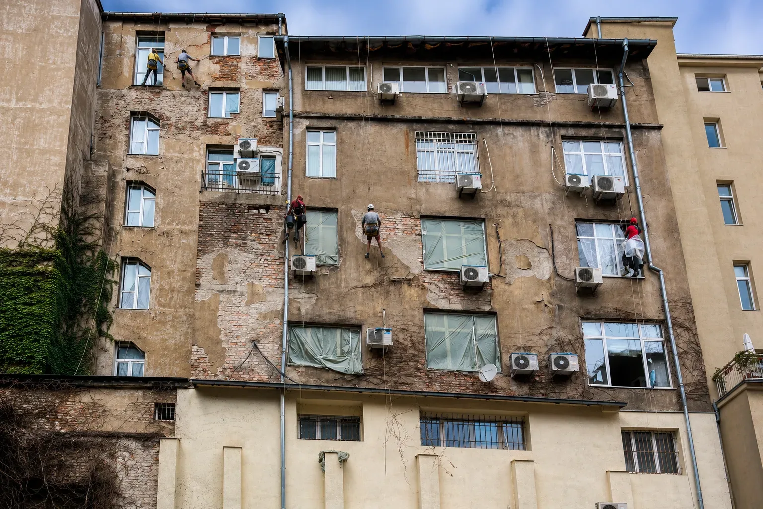 Vista general de técnicos sobre una fachada deteriorada